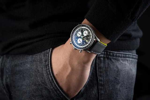 A steel chronograph worn with a dark sweater and jeans